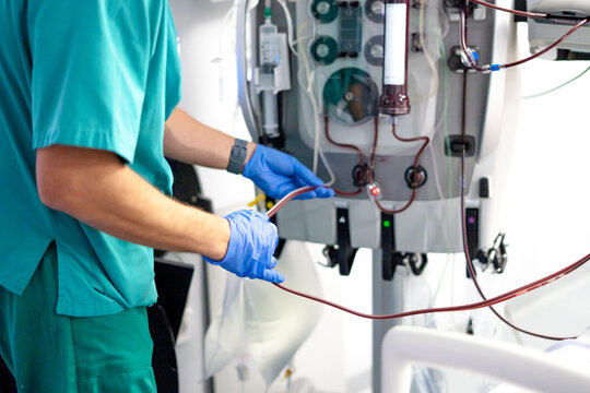 Medical professional preparing dialysis machine for blood filtration