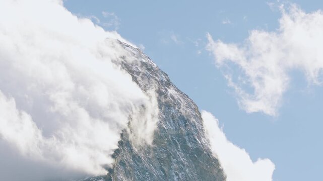 Majestic summit of the matterhorn in the swiss alps surrounded by white clouds against a blue sky