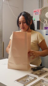 Restaurant worker preparing a takeout food order
