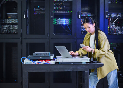 Asian Female Cybersecurity Professional Working in Data Center