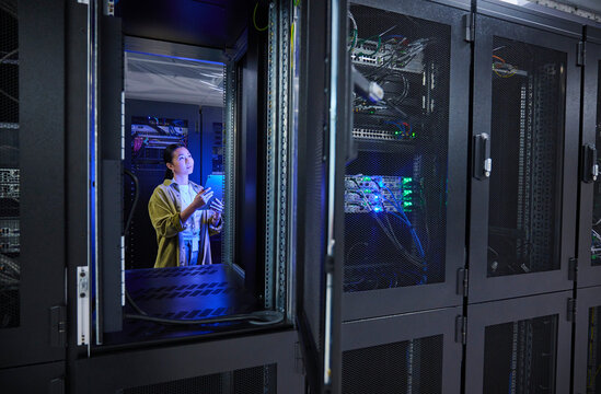 Asian Female Engineer Working in Modern Data Center