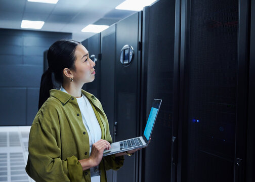 Female Technology Engineer Using Laptop in Data Center