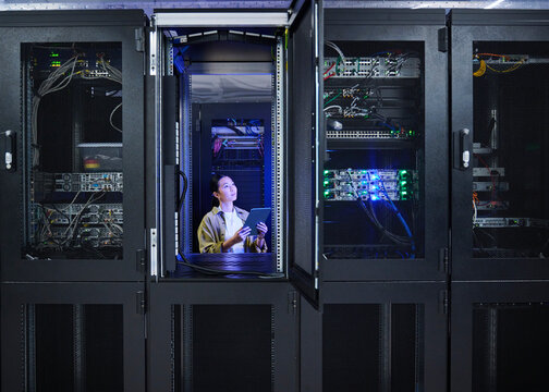 Asian Female Engineer Working in Modern Data Center