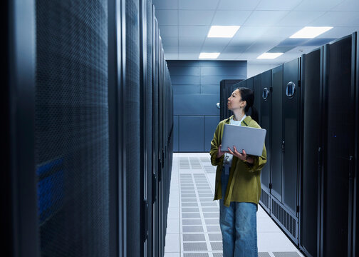 Asian Female Cybersecurity Professional Working in Data Center
