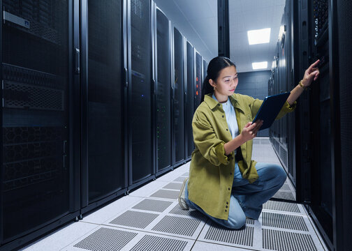 Asian Female Cybersecurity Professional Working in Data Center