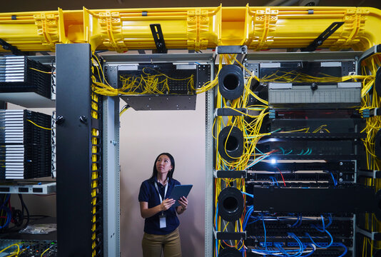 Asian Female Engineer Working in Modern Data Center