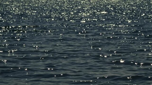 Sun Glare On Dark Blue Sea Water. Ripples On Ocean Waves