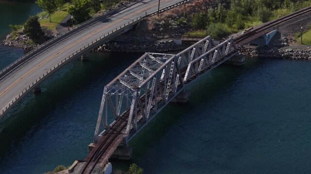 Aerial of paved highway bridge and truss railroad bridge over Columbia River in Pateros Washington in summer