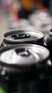 From top-down perspective store shelf is filled with rows of metal cans, alternating beer and sparkling soda labels, cans are tightly packed for efficient retail display and easy inventory handling