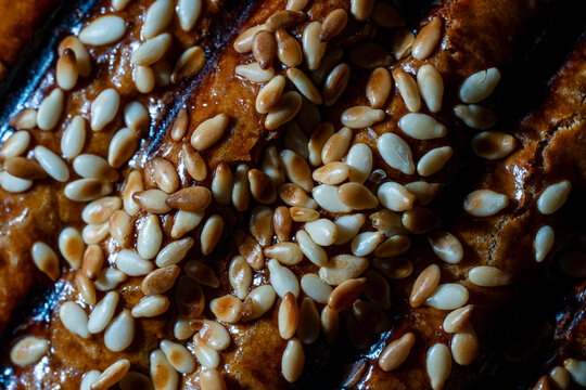Macro texture of golden bread crust with sesame seeds. Closeup macro view of crispy golden brown pastry or bread crust topped with white and toasted sesame seeds representing bakery product quality