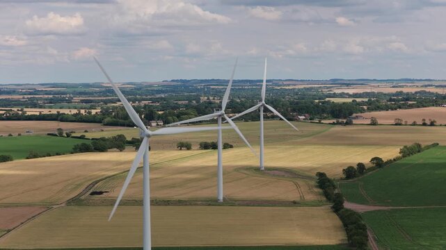 Wind Turbines Turning in Rural Fields on a Cloudy Day