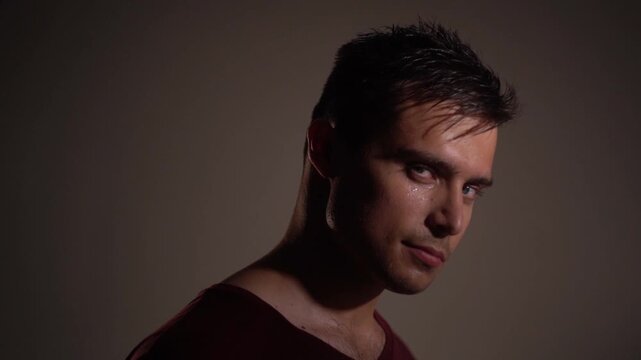 Young man sharply turning head and body to camera, squinting eyes as if recognizing something, scrutinizing, searching expression. 