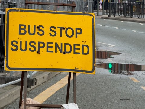 Bus stop suspended sign placed on a wet road