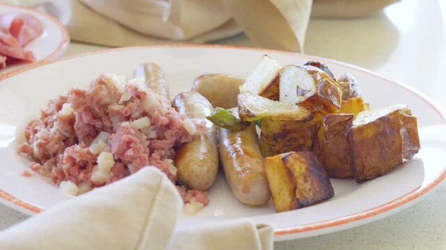 Breakfast plate with corned beef hash sausages and roasted potatoes