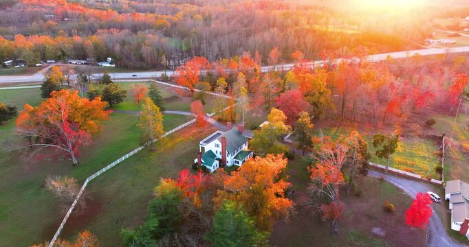 Large traditional homes in forest of autumn colors in Appalachian USA. Yellow and orange trees at sunset in North Carolina countryside.
