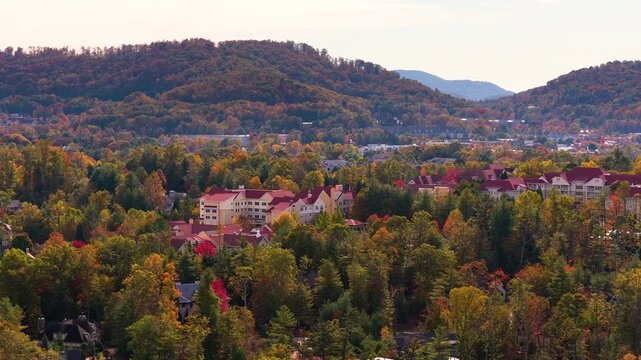 Rural homes overlooking colorful mountain forests near Asheville, North Carolina. Peak autumn foliage creates breathtaking landscape around peaceful community.