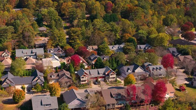 Rural homes overlooking colorful mountain forests near Asheville, North Carolina. Peak autumn foliage creates breathtaking landscape around peaceful community.