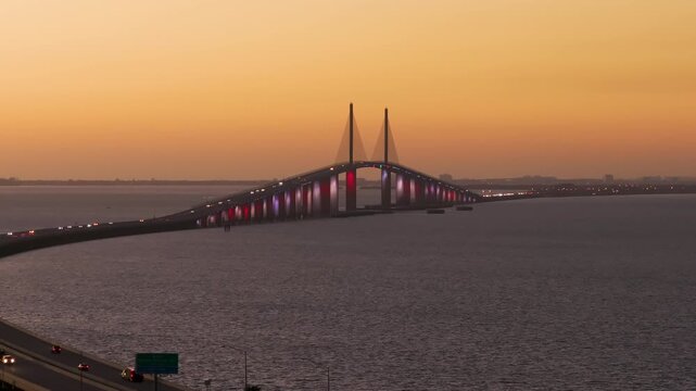 Sunshine Skyway Bridge over Tampa Bay in St Petersburg in Florida with driving traffic cars in evening. Transportation infrastructure in USA