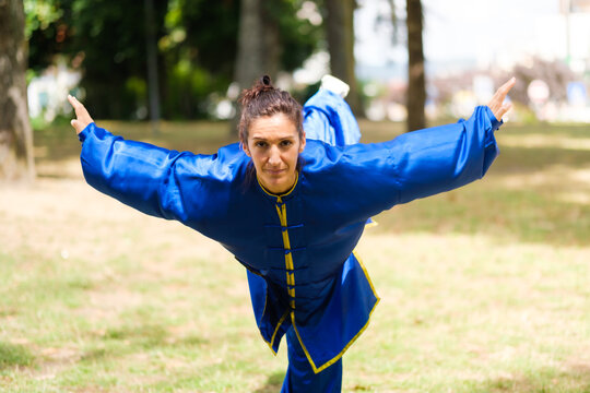 Woman practicing kung fu balance pose outdoors