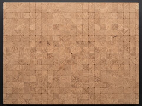 Close-up view of a light-colored wooden end-grain cutting board with a grid pattern of small square blocks.
