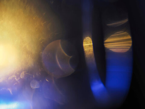 Warm orange and blue light leaks on black. Abstract background for design and special effects. Random shapes and form. Lens flare.