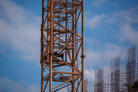 Close-up of a yellow tower crane jib end against clear blue sky with large copy space