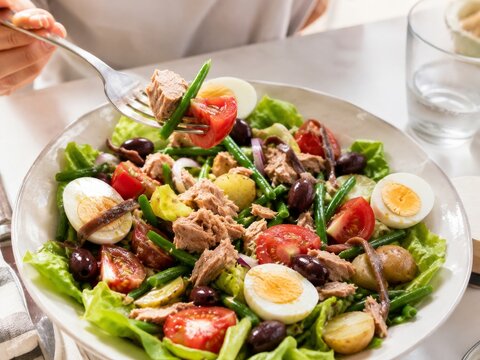 Ensalada de at&uacute;n con huevos duros, tomates y jud&iacute;as verdes en un plato grande con lechuga