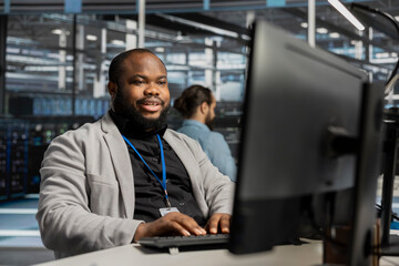 Fototapeta premium Pleased data center worker celebrates a successful server software update in a data center.