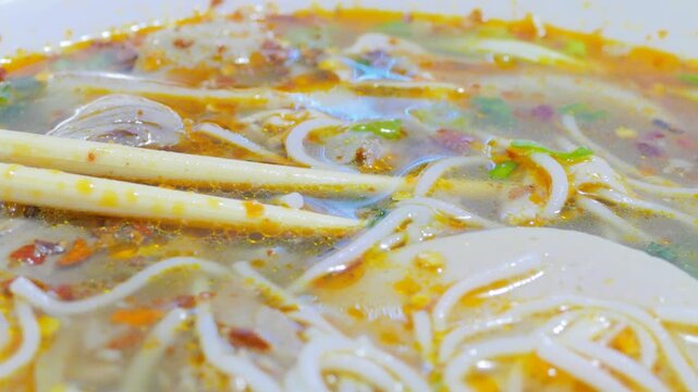 Macro view of spicy Vietnamese bun bo hue noodle soup