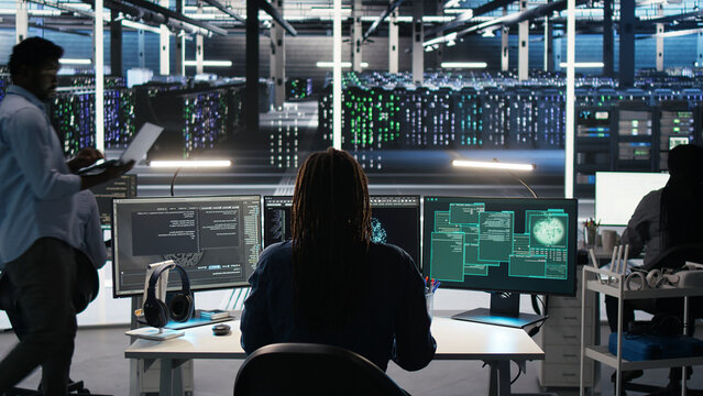 Data center administrator reacts to a cyberattack on a computer, securing server equipment and protecting confidential data.