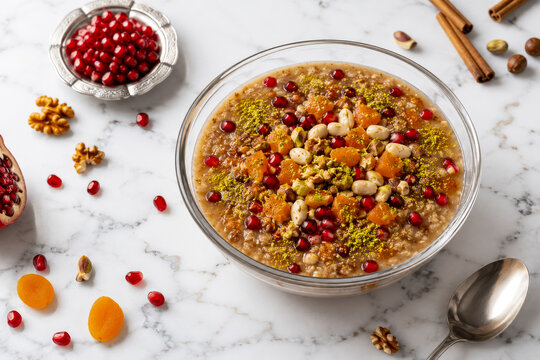 Traditional Turkish Ashure Dessert in Glass Bowl on White Marble Background.