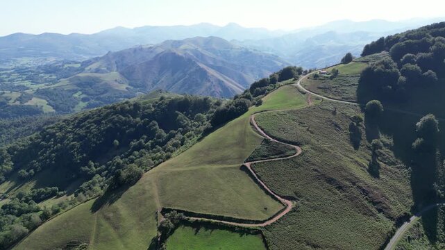 Aerial view of a winding dirt trail along the steep grassy slopes of the French Pyrenees near Saint Jean Pied de Port, Camino de Santiago