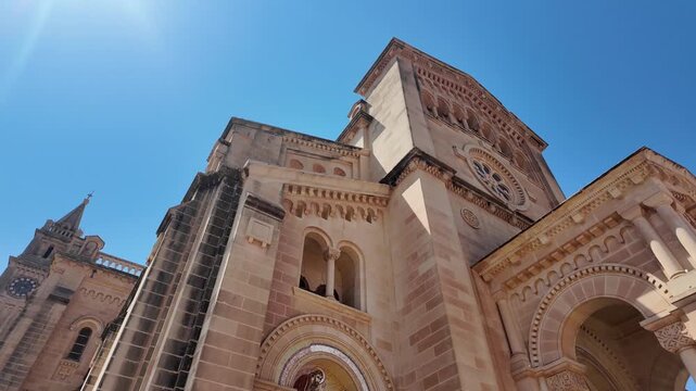 a detailed view of a serene historical building facade in a bright outdoor daytime scene with clear sky and stone materials, emphasizing grandeur and timeless beauty, low-angle shot.