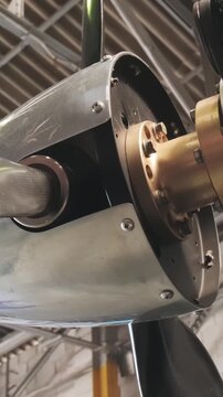 Detailed close-up of aircraft propeller shaft and engine assembly during maintenance procedure, showcasing aviation engineering and airplane propulsion technology.