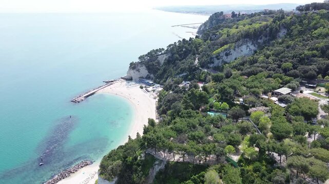 Spiaggia Urbani Beach, Sirolo, Riviera del Conero, Marche, Italy. Aerial drone footage of white limestone cliffs, turquoise Adriatic Sea and sandy beach on a sunny summer day.