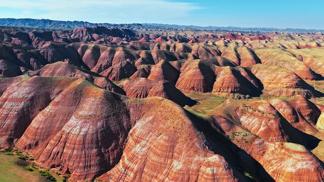Majestic colorful sandstone mountains of Danxia landform under clear blue sky in Xinjiang, China.