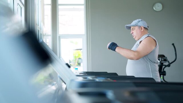 Mature overweight man running workout on treadmill at fitness gym to improve health through cardio exercise weight loss endurance healthy active lifestyle fitness sport training healthy aging wellness