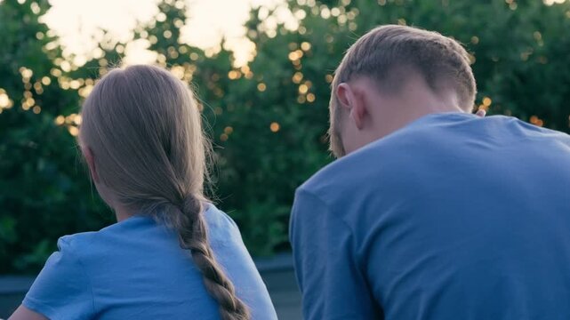 Brother braiding sister's hair: Close-up of gentle sibling bonding in a natural garden setting