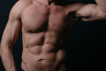 Naklejka premium an athletic-built mature man with a defined abdominal area and large muscles after a grueling workout and a visit to the tanning salon. body parts: firm breasts and elastic muscles. bodybuilding poses