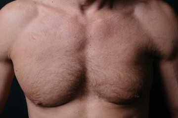 Naklejka premium an athletic-built mature man with a defined abdominal area and large muscles after a grueling workout and a visit to the tanning salon. body parts: firm breasts and elastic muscles. bodybuilding poses