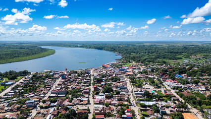 Aerial landscape capturing the striking contrast between Yarinacocha's tin roofs, dense amazon foliage, and the distant riverbank. © Marcelo