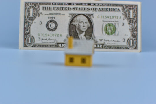 Tiny houses sit before a one-dollar bill