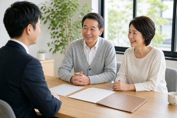 Obraz premium 相談室で笑顔を見せるシニア夫婦と専門家