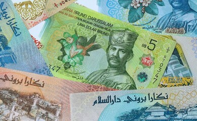 Brunei dollar money banknotes bunch on table. Brunei bills of BND currency close up © Larysa