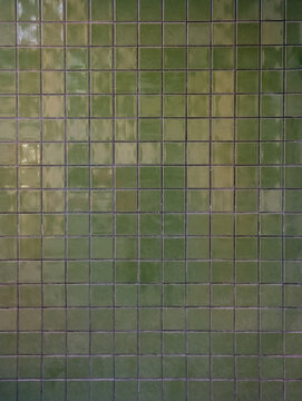 Glossy olive green ceramic mosaic tile texture wall background, small glazed square gresite tiles pattern, modern outdoor architectural finish decoration. Architecture, pool interior, spa design.