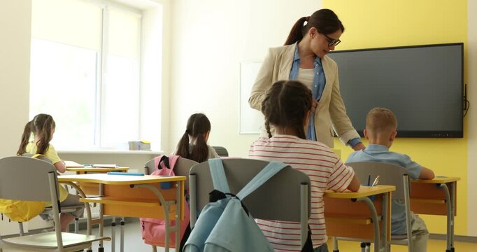 Teacher checking on students during lesson in classroom