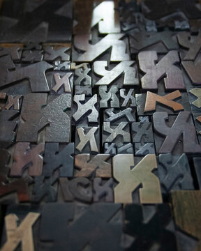 Collection of traditional letterpress printing equipment, metal type, wooden letters and vintage typography tools used in historical printing and typesetting.