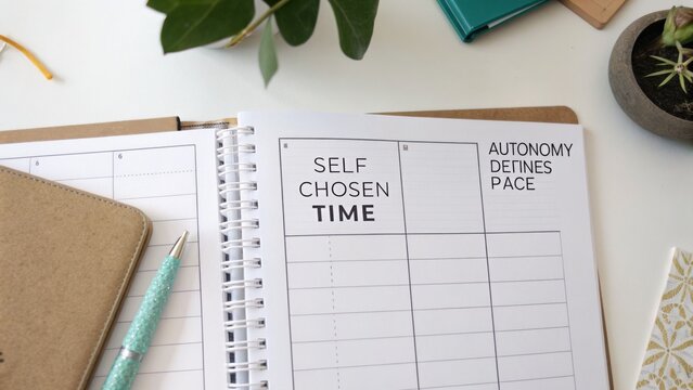 Stylish desk setup featuring a planner with motivational quotes on time management and a plant adding a touch of greenery