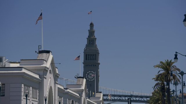 Ferry Building Clock Tower With American Flag Over Clear Blue Sky In San Francisco