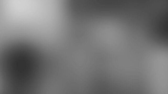 Abstract grayscale background with soft moving light leaks and cinematic texture.
